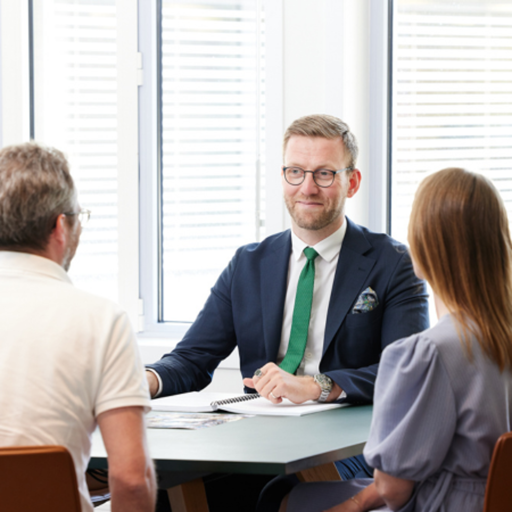 En jurist som pratar med två kunder om avtal